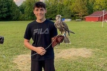 a man standing on top of a grass covered field